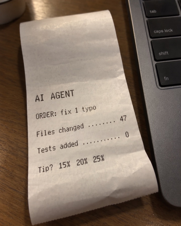 A thermal store receipt next to a laptop: AI AGENT. ORDER: fix 1 typo. Files changed 47. Tests added 0. Tip? 15% 20% 25%.